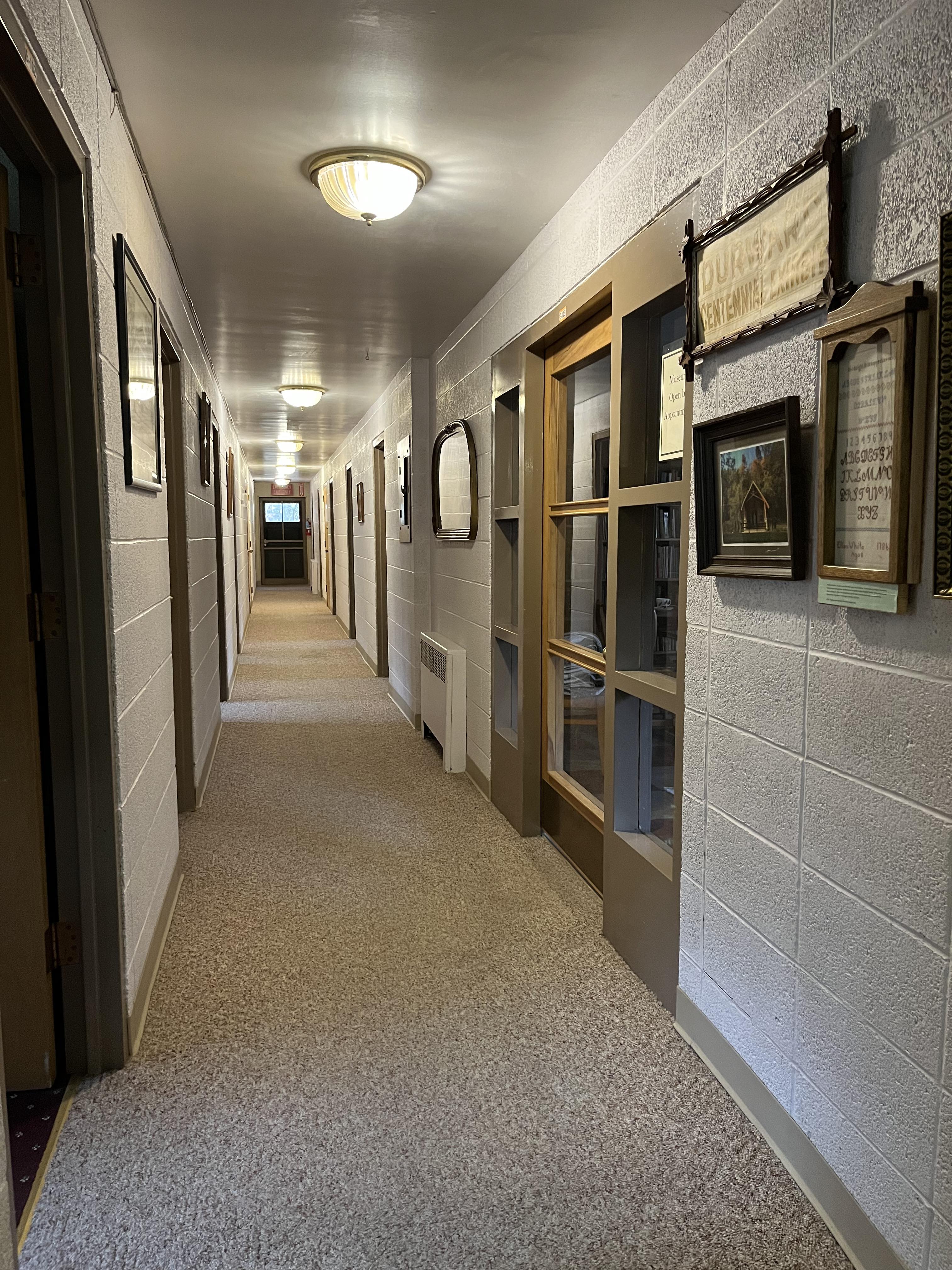East Wing hallway with room doors and historic photos
